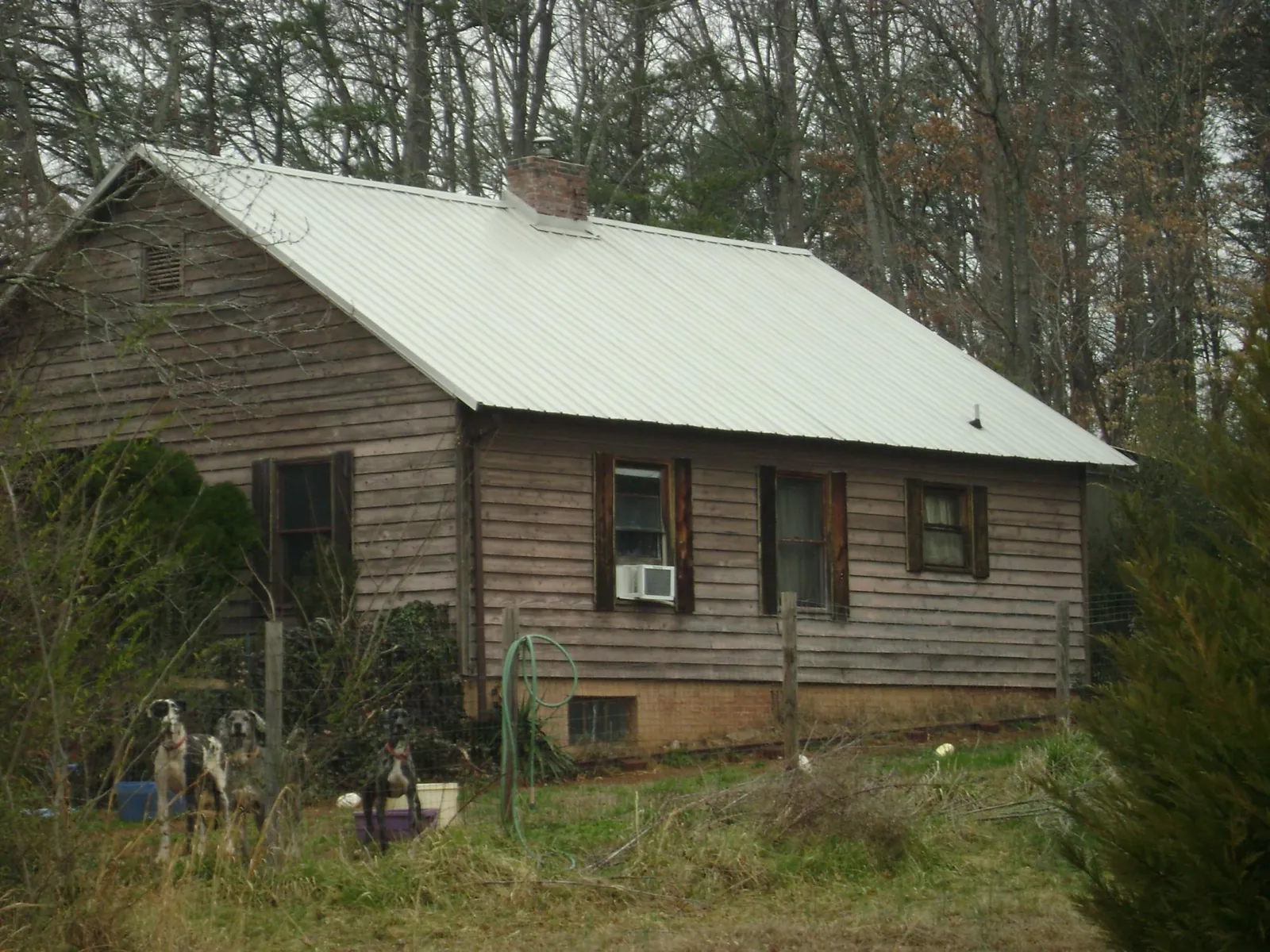 White metal roof on an old wood sided farmhouse, from a Metal Roof Installation job in Russellville